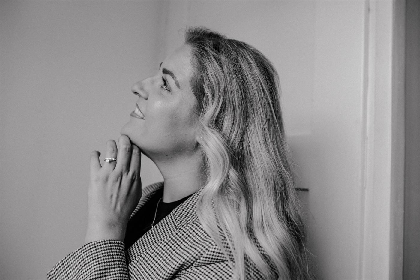 Lara Holzhofer im Profil vor einer hellen Wand, Schwarzweißaufnahme