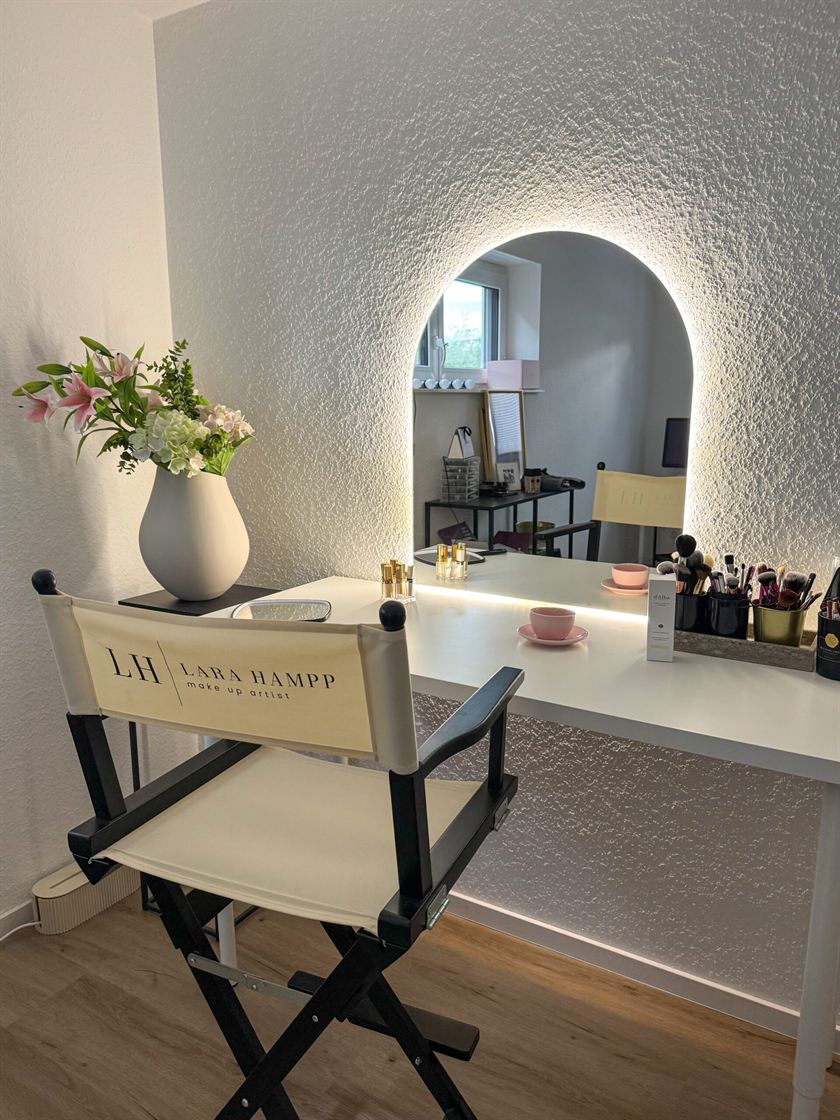 Schminkplatz mit beleuchtetem Bogenspiegel, Regiestuhl und Pinseln